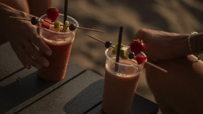 Due cocktail alla frutta con decorazioni di frutta serviti su un tavolo nero