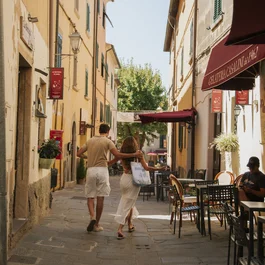 Coppia che cammina in una strada stretta con caffè all'aperto in una giornata di sole