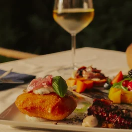 Piatto gourmet con cibo raffinato e bicchiere di vino bianco