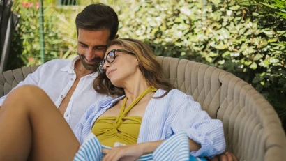 Coppia rilassata seduta su una poltrona all'aperto in giardino