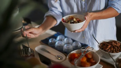Persona che prepara una ciotola con frutta secca e yogurt