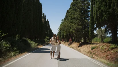 Coppia che legge una mappa su una strada alberata in una giornata soleggiata