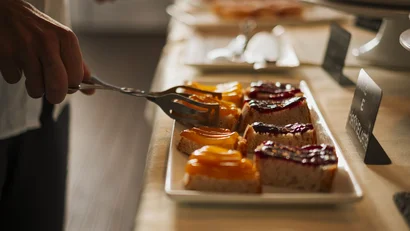 Torta a fette con glassa gialla e rossa servita con una forchetta