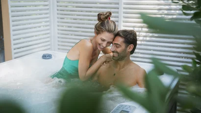 Coppia felice che si coccola in una vasca idromassaggio all'aperto