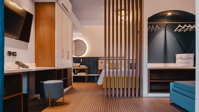 Camera d'albergo moderna con letto, TV, guardaroba e bagno separato