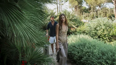 Coppia che cammina su un sentiero nel giardino verde con piante rigogliose