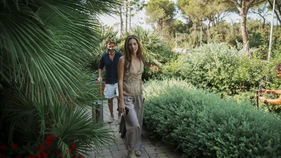 Coppia che cammina su un sentiero nel giardino verde con piante rigogliose